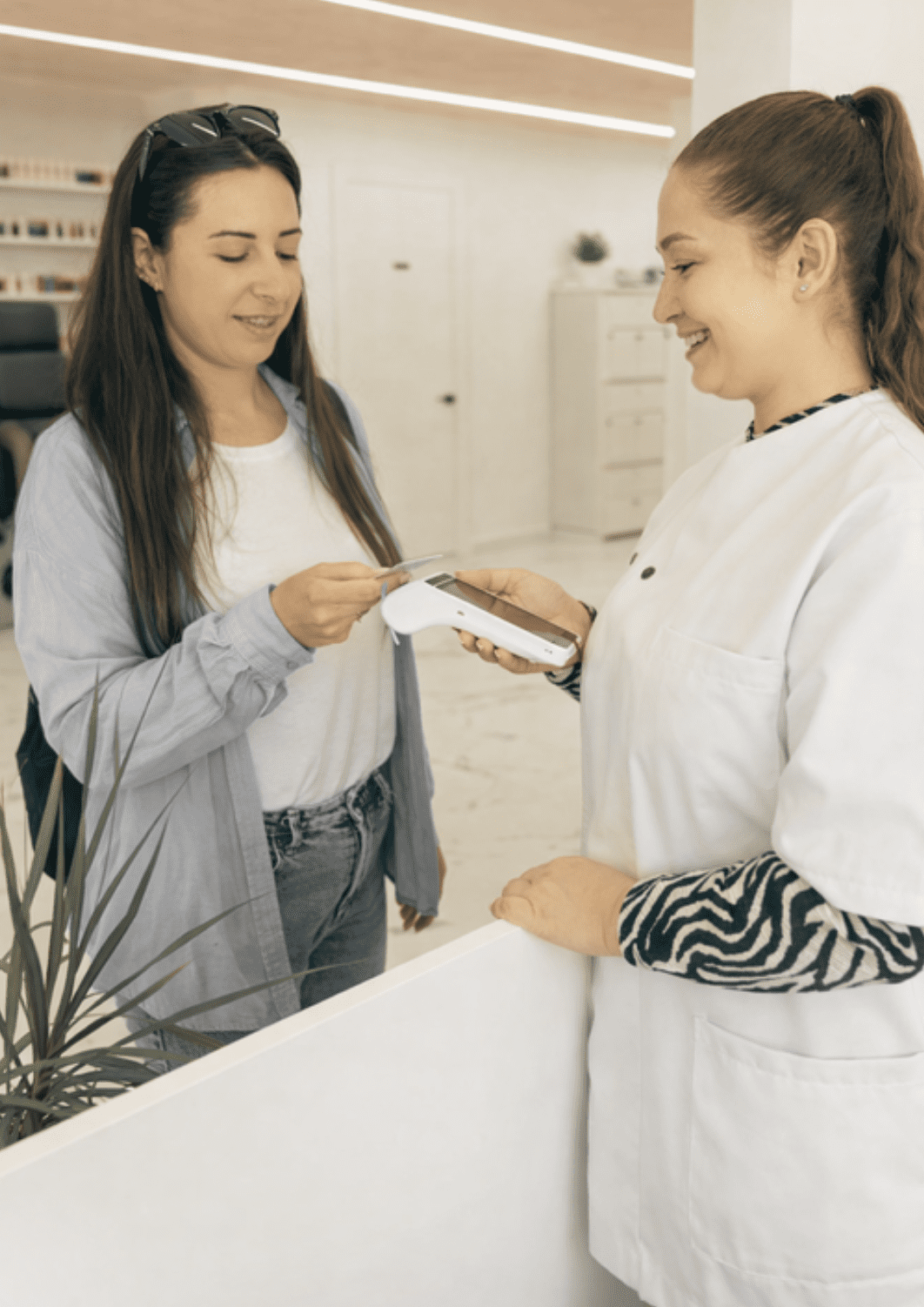Salon professional accepting a card payment from a customer